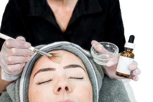 Close up of beautician (cosmetologist) applying chemical peel tr