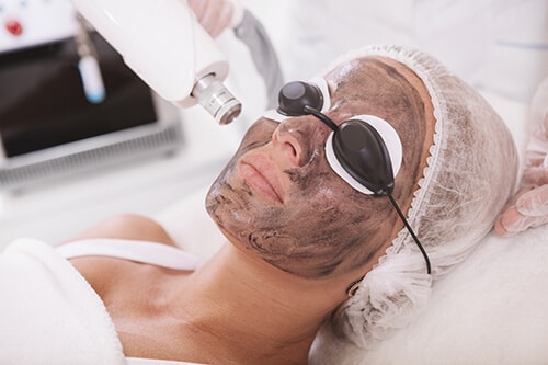 Mature woman getting facial skincare treatment at beauty salon